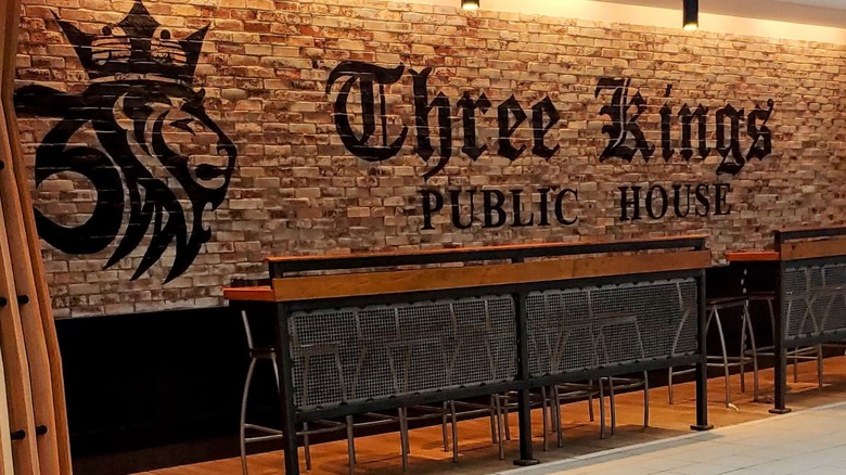 Asientos en Three Kings Public House con vista al vestíbulo del aeropuerto