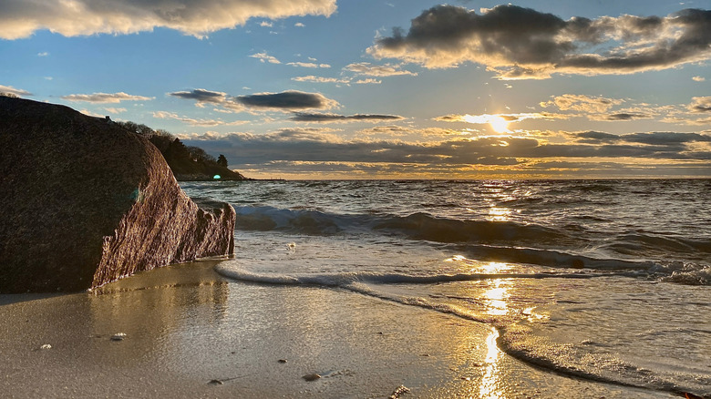 Atardecer en Old Silver Beach en Cape Cod con luz dorada reflejada en las olas en la orilla